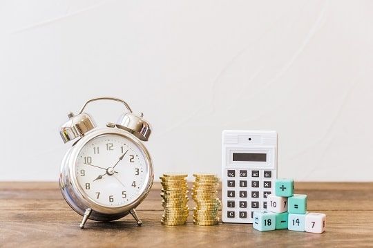 Image of a clock, coins, calculator and blocks.